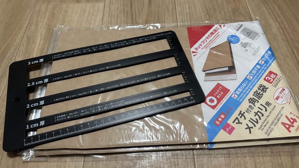 メルカリで使えるサイズを図る定規と、百均で購入した猫ポス用封筒の写真